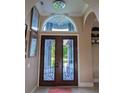 Elegant entryway with double doors, chandelier, and arched window at 2761 Newman Dr, North Port, FL 34288
