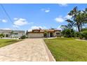 Single-Gathering house with a paved driveway and manicured lawn at 16681 Acapulco Rd, Punta Gorda, FL 33955