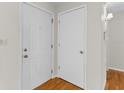 Bright entryway showcasing a white front door and a closet door, complemented by wood floors at 1585 Harmony Dr, Port Charlotte, FL 33952