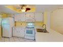 White kitchen with appliances, good counter space and yellow walls at 3310 Loveland Blvd # 1604, Punta Gorda, FL 33980