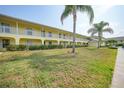 Two-story yellow building with balconies and lawn at 4000 Bal Harbor Blvd # 214, Punta Gorda, FL 33950