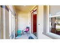 Inviting entryway with red door and small seating area at 10034 Winding River Rd, Punta Gorda, FL 33950