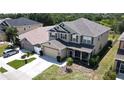 Two-story house with gray roof, tan siding, and a landscaped yard at 10034 Winding River Rd, Punta Gorda, FL 33950