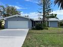 Updated home exterior featuring a white garage door and manicured lawn at 75 Annapolis Ln, Rotonda West, FL 33947