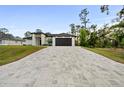 Long patterned concrete driveway leading up to a modern home with well-maintained landscaping at 5815 Casanova Ave, North Port, FL 34291