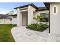 View of front entrance featuring stone pathway, manicured landscaping, and modern architectural details at 5815 Casanova Ave, North Port, FL 34291