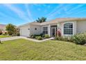 House exterior with a two-car garage and manicured lawn at 24449 Manchester Trl, Punta Gorda, FL 33980