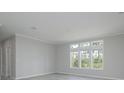 Bright living room with gray walls, wood-look flooring, and large windows at 8191 Strasse Blvd, Punta Gorda, FL 33982