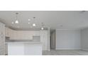 Modern kitchen with white cabinets, a large island, and gray flooring at 8191 Strasse Blvd, Punta Gorda, FL 33982