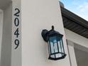 Close-up shot of the house number and outdoor light fixture on the exterior at 2049 Delta St, Port Charlotte, FL 33952
