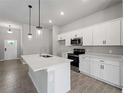 Bright kitchen with stainless appliances, white cabinetry, and a center island with sink at 2049 Delta St, Port Charlotte, FL 33952
