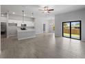 Spacious open floor plan featuring wood-look tile, large sliding glass doors, and open kitchen at 2049 Delta St, Port Charlotte, FL 33952
