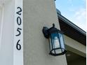 Close-up of house number 2056 with modern wall mounted exterior light fixture at 2056 Ellery St, Port Charlotte, FL 33952