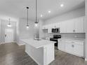 Modern kitchen boasts sleek white cabinets, stainless steel appliances, and center island at 2056 Ellery St, Port Charlotte, FL 33952