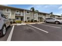 Condo building exterior showcasing parking spaces and landscaping at 3310 Loveland Blvd # 1502, Punta Gorda, FL 33980
