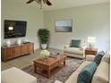Bright living room featuring a comfy seating area and large TV at 1160 Belkton Ave, Port Charlotte, FL 33948