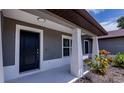 Modern front porch with gray exterior, black door and yellow flowers at 4351 Antioch St, North Port, FL 34288