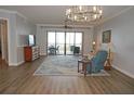Relaxing living room with hardwood floors, access to a balcony with water views, and ample natural light at 87 Vivante Blvd # 8742, Punta Gorda, FL 33950