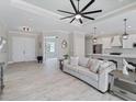 Open-concept living room featuring tray ceilings, wood-look tile floors and an island with bar stool seating at 13348 Rayburn Ln, Port Charlotte, FL 33981