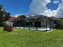 Screened-in pool area with grassy backyard at 4419 Crews Ct, Port Charlotte, FL 33952