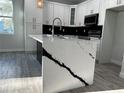 Kitchen island with white quartz countertop and dark lower cabinets at 1259 Kaayan St, North Port, FL 34288