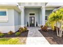 Inviting front entry with a walkway and lush landscaping at 9978 Audrey St, Port Charlotte, FL 33981