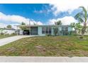 Inviting home featuring an attached carport and a well-kept lawn at 22062 Marshall Ave, Port Charlotte, FL 33952
