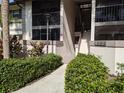 Condo building entrance with stairs and manicured landscaping at 1515 Forrest Nelson Blvd # E106, Port Charlotte, FL 33952