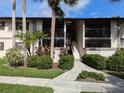 Exterior view of condo building with lush landscaping and walkway at 1515 Forrest Nelson Blvd # E106, Port Charlotte, FL 33952