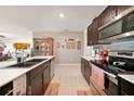 Modern kitchen with dark cabinetry, stainless steel appliances, and a large island at 27441 Natal Dr, Punta Gorda, FL 33983