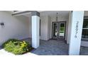 Covered front entry with double doors and gray pavers at 28976 Gin Ln, Punta Gorda, FL 33982