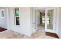 White house exterior with glass double doors leading inside from a brick patio at 28992 Gin Ln, Punta Gorda, FL 33982