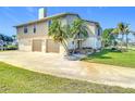 Two-story home with two-car garage, palm trees, and well-kept front yard at 24313 Pirate Harbor Blvd, Punta Gorda, FL 33955