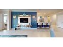 Open concept living room with a blue accent wall, tile flooring, modern entertainment center, and kitchen island at 7168 W Lenox Cir, Punta Gorda, FL 33950