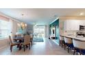 An open-concept living space featuring a dining area, living room, and kitchen with modern finishes and ample natural light at 7168 W Lenox Cir, Punta Gorda, FL 33950
