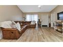 Living room with a brown leather sectional sofa and wood-look tile floors at 3300 Loveland Blvd # 1301, Punta Gorda, FL 33980