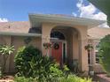 One story home with coral front door and lush landscaping at 7100 Mineola Rd, Englewood, FL 34224