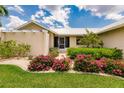 Landscaped front yard with flowering bushes and a metal roof at 3621 Whippoorwill Blvd, Punta Gorda, FL 33950