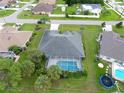 An aerial shot showcases a well-maintained home with a screened pool in a verdant neighborhood at 515 Allworthy St, Port Charlotte, FL 33954