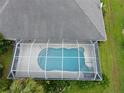 Aerial view of a private screened-in pool with surrounding tile patio and clear blue water at 515 Allworthy St, Port Charlotte, FL 33954