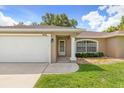 Tan house with white garage door and columns at 4116 Pine Cone Ter, North Port, FL 34286