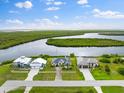 Aerial view of three waterfront homes with lush landscaping and access to a tranquil waterway at 5189 Collingswood Blvd, Port Charlotte, FL 33948