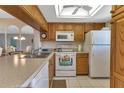 Bright kitchen with wood cabinets, white appliances, and a large island at 25275 Rampart Blvd # 1801, Punta Gorda, FL 33983