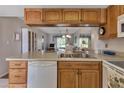 Open kitchen with wood cabinets, white appliances, and a view to the living area at 25275 Rampart Blvd # 1801, Punta Gorda, FL 33983