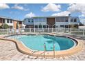 Community pool with brick patio and surrounding fence at 22333 Edgewater Dr # B8, Port Charlotte, FL 33980