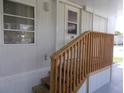 Wooden steps leading to the entrance of the manufactured home at 5505 Holiday Park Blvd, North Port, FL 34287
