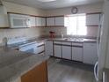 Galley kitchen with granite countertops and white appliances at 5505 Holiday Park Blvd, North Port, FL 34287