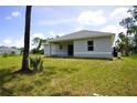 Backyard exterior view of home features a patio with sliding doors and views of the landscaped yard at 2163 Blaser St, Punta Gorda, FL 33980