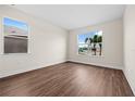 Bright bedroom with wood-look flooring and large windows at 42548 Little Ridge Rd, Punta Gorda, FL 33982