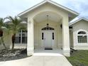 Front entrance with arched entryway and attractive landscaping at 530 Kensington St, Port Charlotte, FL 33954